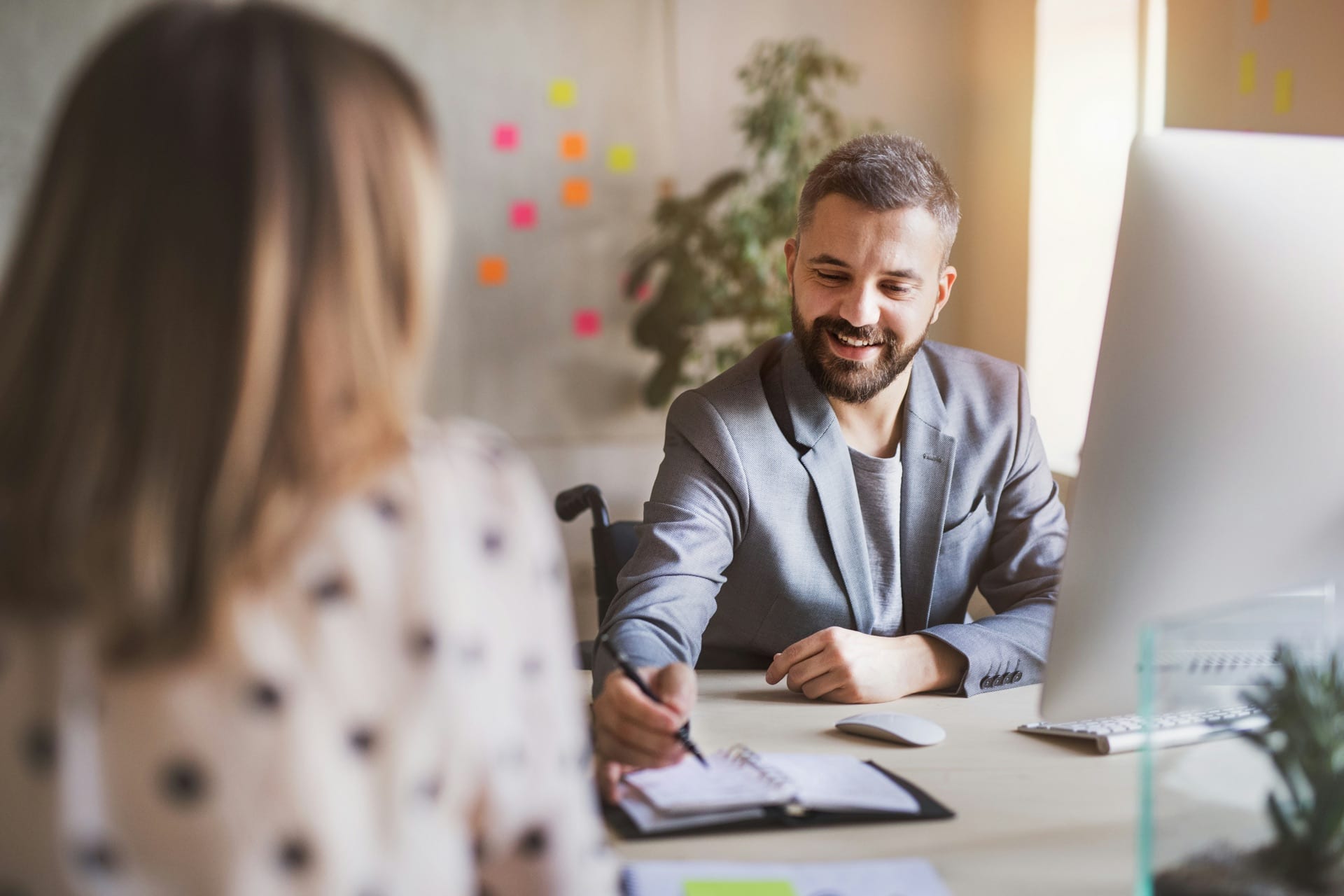 Werkgever en medewerker in gesprek aan een bureau